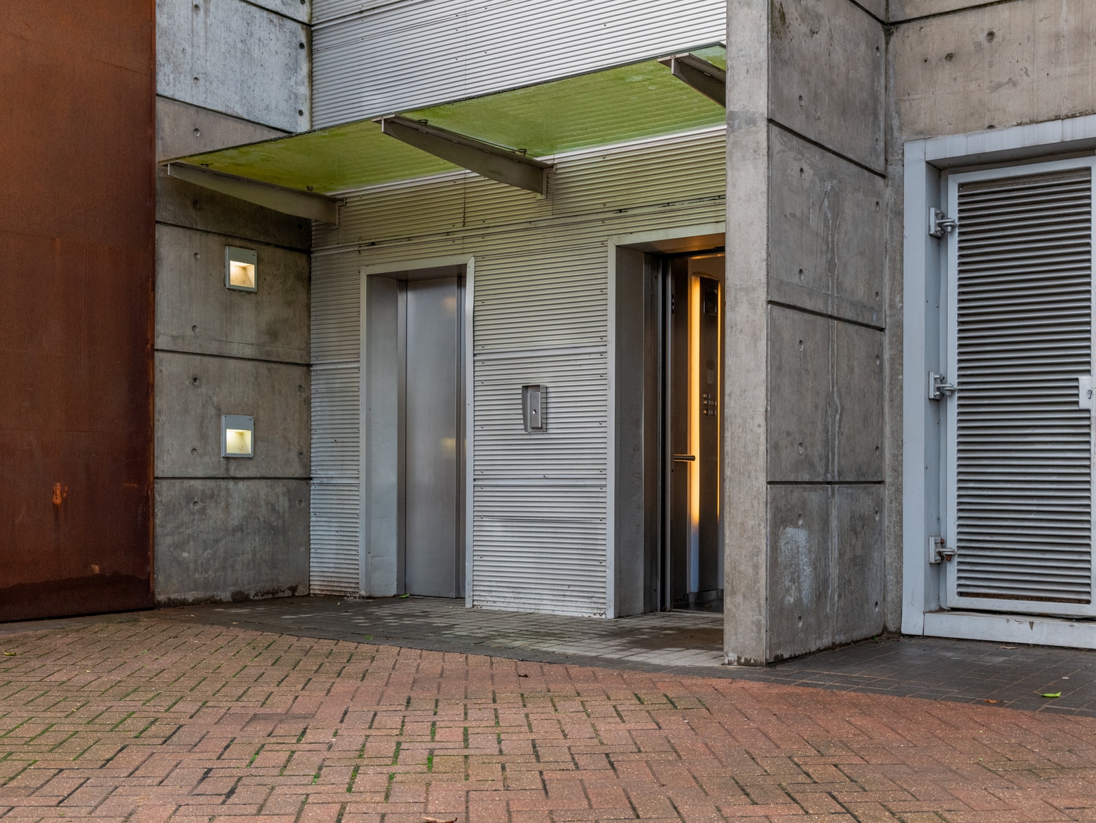 gray wooden door on brown brick wall